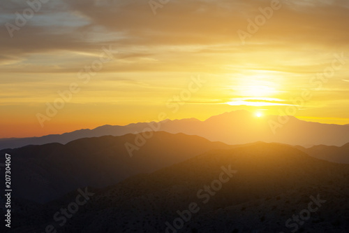 Sunlight shining over a colorful desert mountain landscape in California © deberarr
