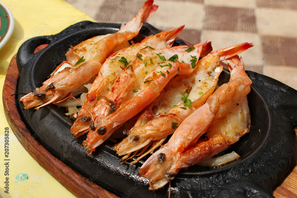 Baked royal prawns served on a hot plate Baked royal prawns served on a hot plate