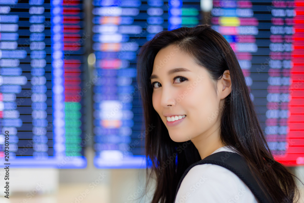 Charming beautiful tourist woman stand in front of timetable. Attractive traveler woman love travel when she get holiday. Gorgeous girl stand at airport and happy, satisfie airline, airport of service Charming beautiful tourist woman stand in front of timetable. Attractive traveler woman love travel when she get holiday. Gorgeous girl stand at airport and happy, satisfie airline, airport of service
