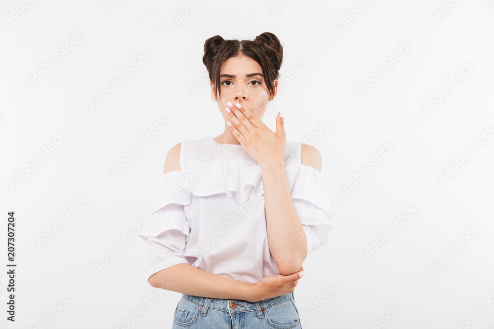 Photo of shocked caucasian woman with double buns hairstyle covering open mouth in disappointment, isolated over white background Photo of shocked caucasian woman with double buns hairstyle covering open mouth in disappointment, isolated over white background