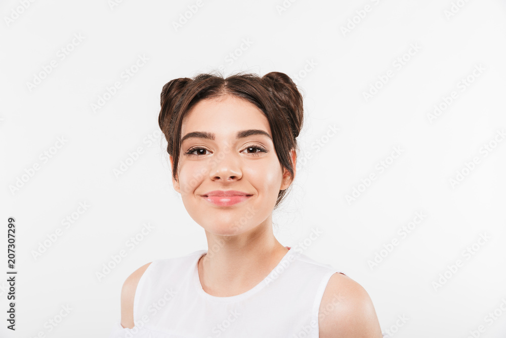 Portrait closeup of beautiful teenage girl 20s with double buns hairstyle smiling at camera in happy mood, isolated over white background Portrait closeup of beautiful teenage girl 20s with double buns hairstyle smiling at camera in happy mood, isolated over white background