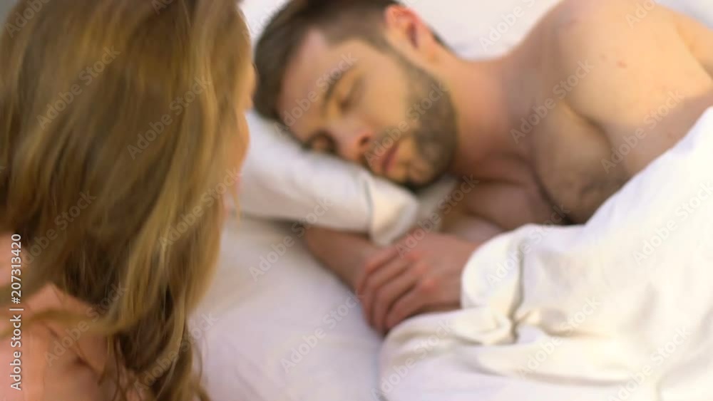 Female kissing her sleeping husband and leaving room, relationship, closeup Female kissing her sleeping husband and leaving room, relationship, closeup