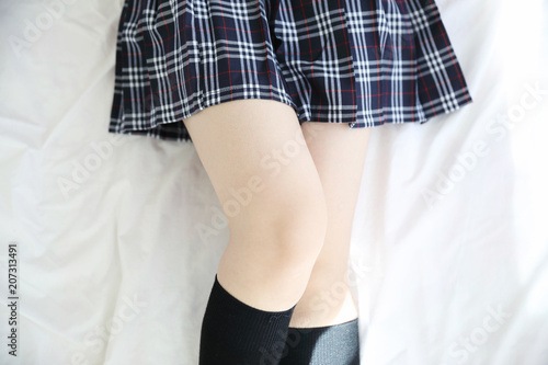Portrait japanese school girl costume legs in white tone bed room