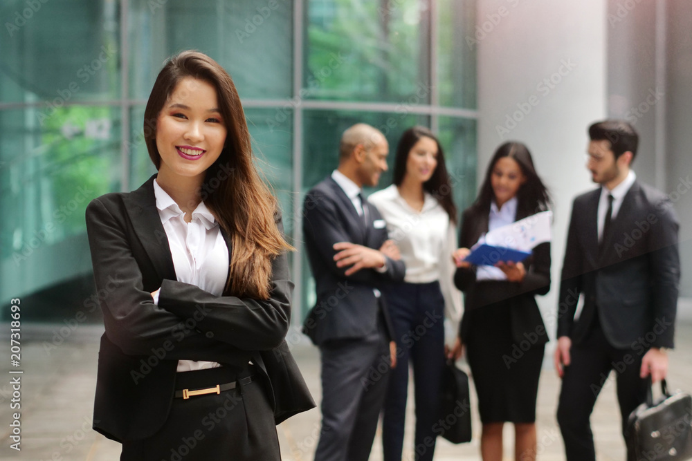 Portrait of business people of different ethnic backgrounds dressed in suits, they smile and cross their arms. Concept of: internationality and career, cooperation and team. Portrait of business people of different ethnic backgrounds dressed in suits, they smile and cross their arms. Concept of: internationality and career, cooperation and team.