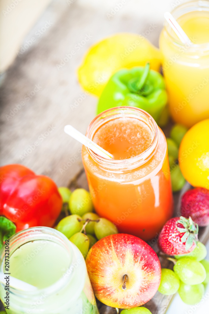 freshly squeezed fruit juice, smoothies yellow orange green blue banana lemon apple orange kiwi grape strawberry on a dark wooden background Copy space freshly squeezed fruit juice, smoothies yellow orange green blue banana lemon apple orange kiwi grape strawberry on a dark wooden background Copy space