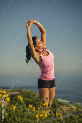Woman stretching against blue sky photo
