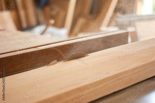 Close up electric saw to sawing wood board, solf focus.