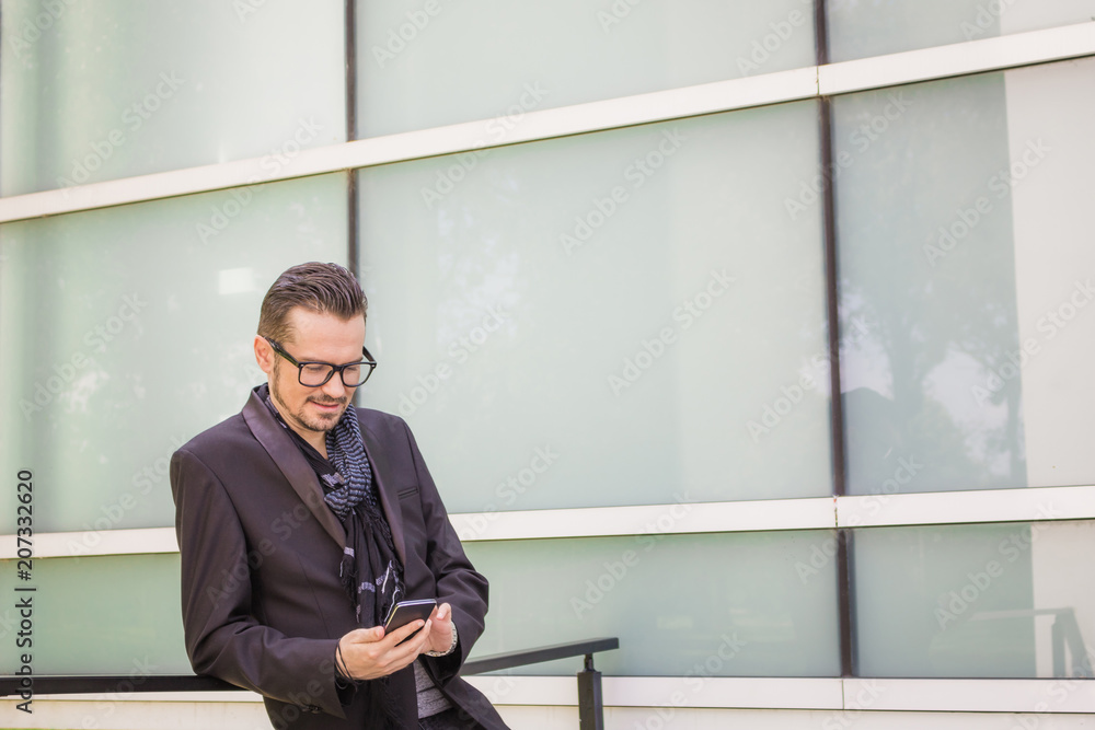 Smiling businessman reading text message on mobile phone. Smiling businessman reading text message on mobile phone.