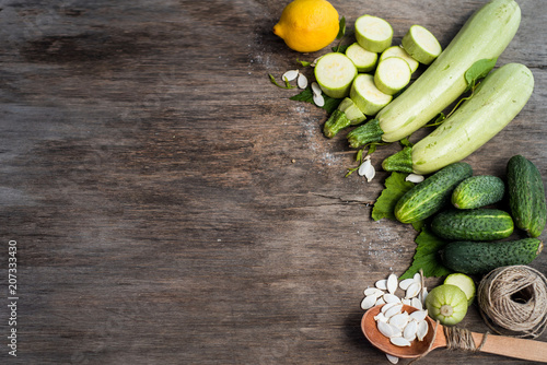 Raw zucchini and cucumbers with different seeds on  the wooden background. top view. Copy space