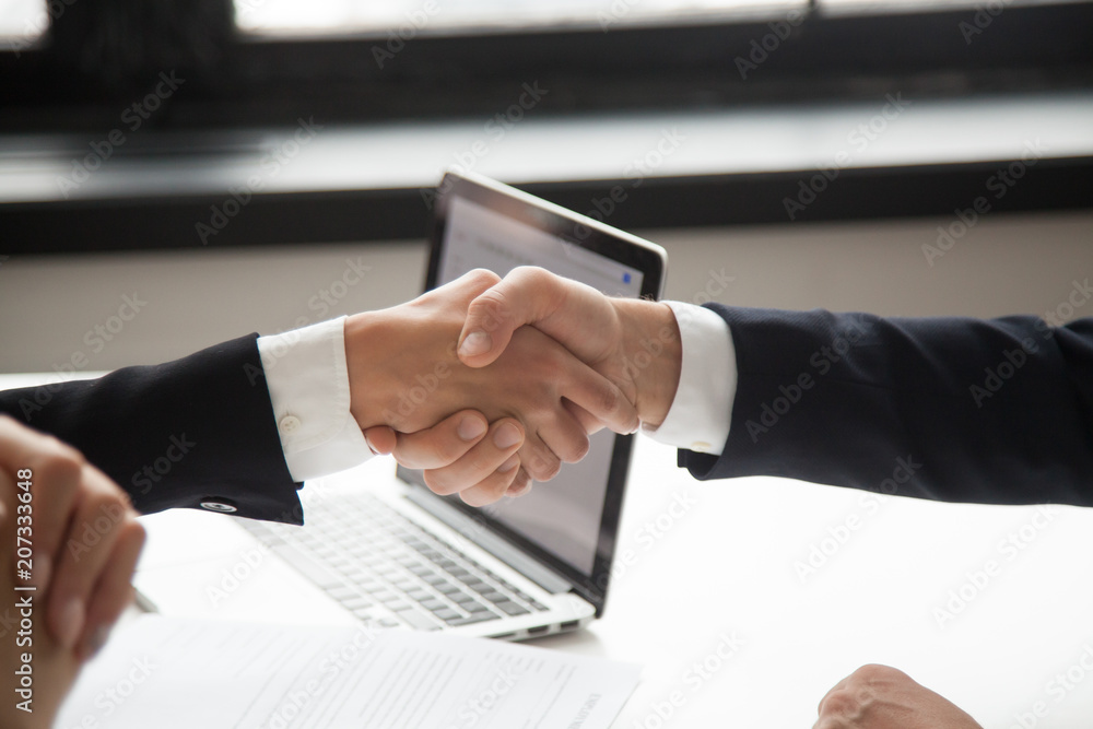 Businessman handshaking businesswoman as concept of good business deal and respect for new partner, successful partnership and great teamwork, hiring, close up view of male female hands shaking Businessman handshaking businesswoman as concept of good business deal and respect for new partner, successful partnership and great teamwork, hiring, close up view of male female hands shaking