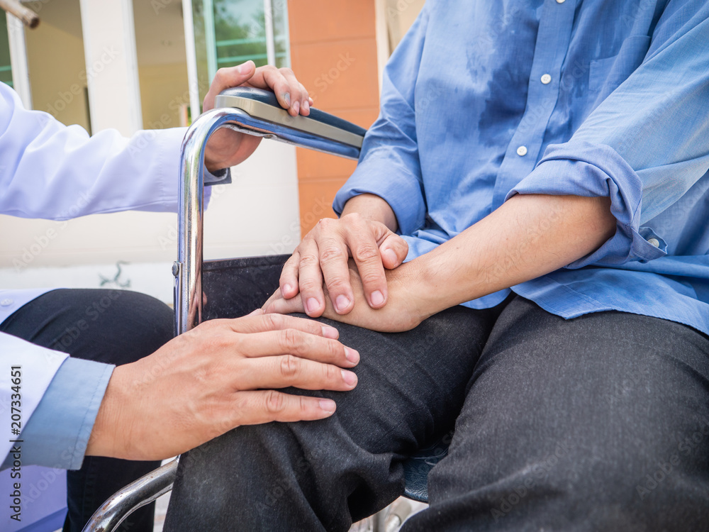 Doctor hold hand patient on wheelchair. Doctor hold hand patient on wheelchair.
