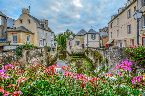 Fototapeta Naklejka Na Ścianę i Meble -  The picturesque French town of Bayeux France near the coast of Normandy with it's medieval houses overlooking the River Aure on an overcast day