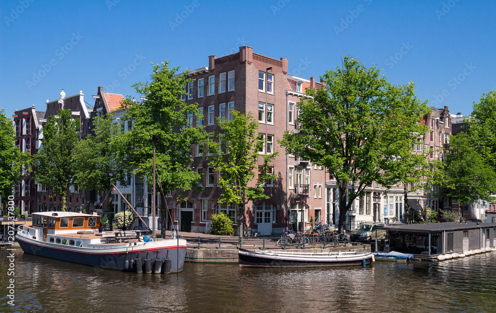 Beautiful landscape with medieval houses and boats on the canal in Amsterdam.