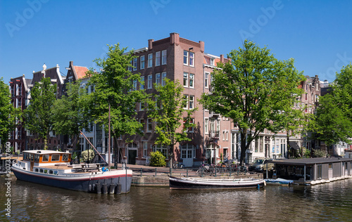 Beautiful landscape with medieval houses and boats on the canal in Amsterdam. © kovalenkovpetr