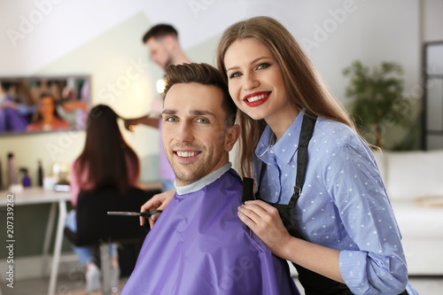 Hairdresser with happy client in beauty salon