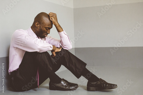 Upset businessman sitting on floor