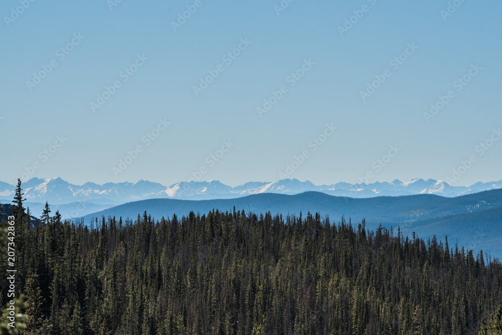 Landscape of snow capped mountains and trees in Colorado's Rocky Mountain National Park.