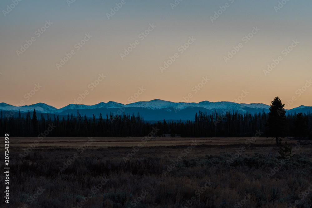 Sunset landscape overlooking a meadow and mountains in Colorado's Rocky Mountain National Park. 
