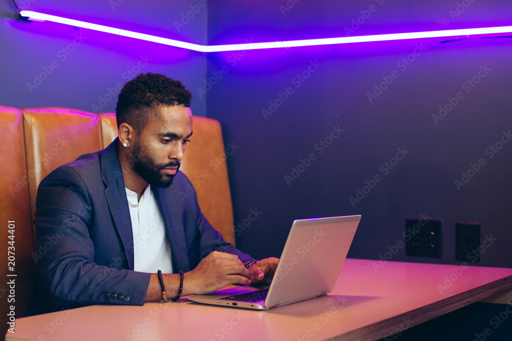 Young businessman working on laptop while sitting in office Young businessman working on laptop while sitting in office