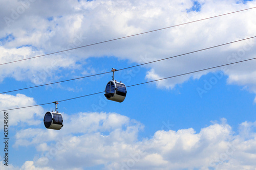 Cabins of the cable car on a background of blue sky with clouds