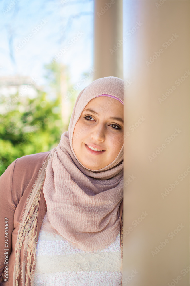 Smiling woman leaning against the column Smiling woman leaning against the column