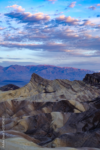 Fototapeta Naklejka Na Ścianę i Meble -  Sunrise begins to kiss the mountain sierra mountains in the background at Zabriskie Point in Death Valley California