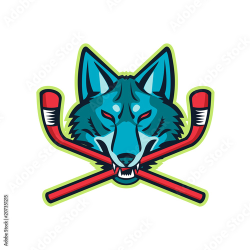 Sports mascot icon illustration of head of a coyote or gray wolf biting a crossed hockey stick viewed from front on isolated background in retro style.
