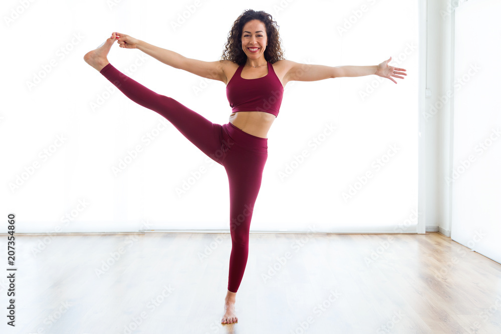 Pretty young woman practicing yoga at home. Utthita hasta padangushtasana pose. Pretty young woman practicing yoga at home. Utthita hasta padangushtasana pose.