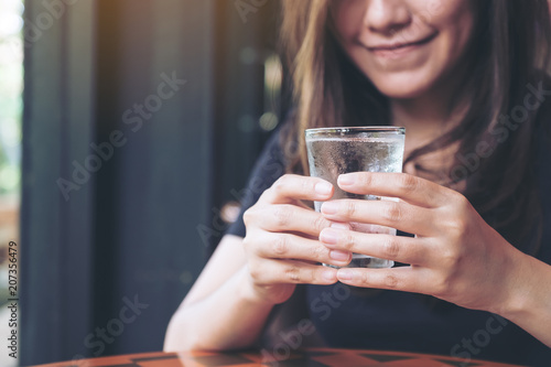 Closeup image of woman holding a glass of cold water to drink