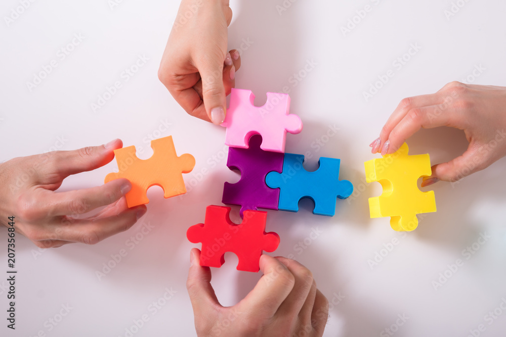 Group Of Businesspeople Solving Jigsaw Puzzle Group Of Businesspeople Solving Jigsaw Puzzle
