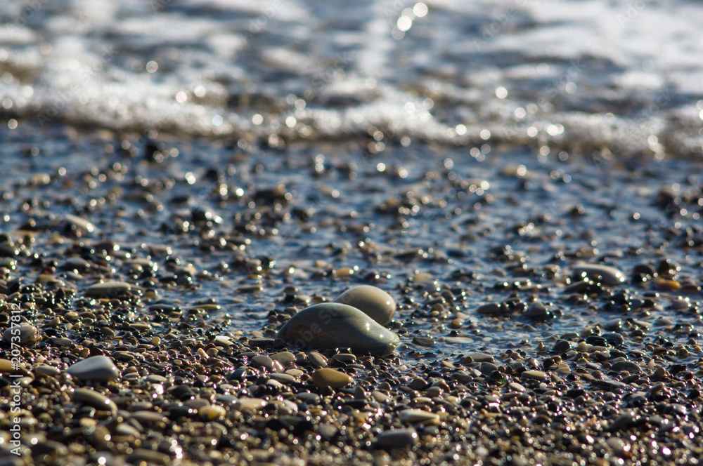 pebble stones on the sea beach, the rolling waves of the sea with foam pebble stones on the sea beach, the rolling waves of the sea with foam