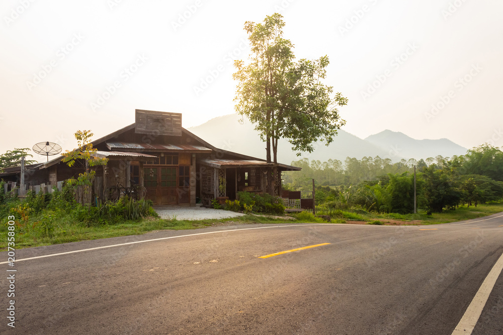 Old Farmhouse on Curve Asphalt Road Through Green Forest On The Mountains, Thailand. Old Farmhouse on Curve Asphalt Road Through Green Forest On The Mountains, Thailand.