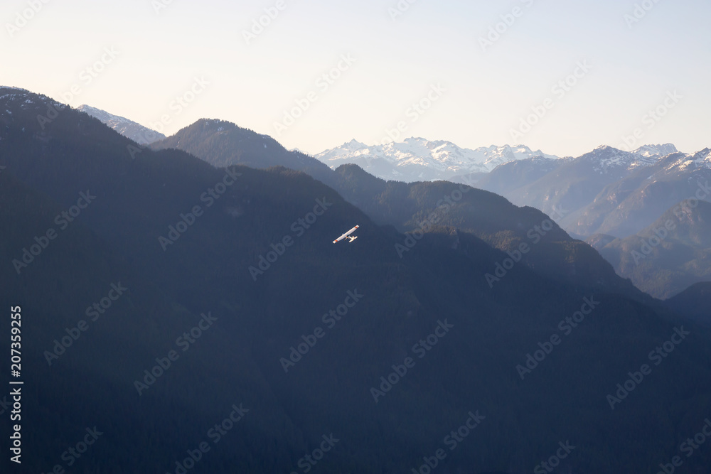 Aerial view of the beautiful Canadian Mountain Landscape with an airplane flying. Taken North of Vancouver, British Columbia, Canada.