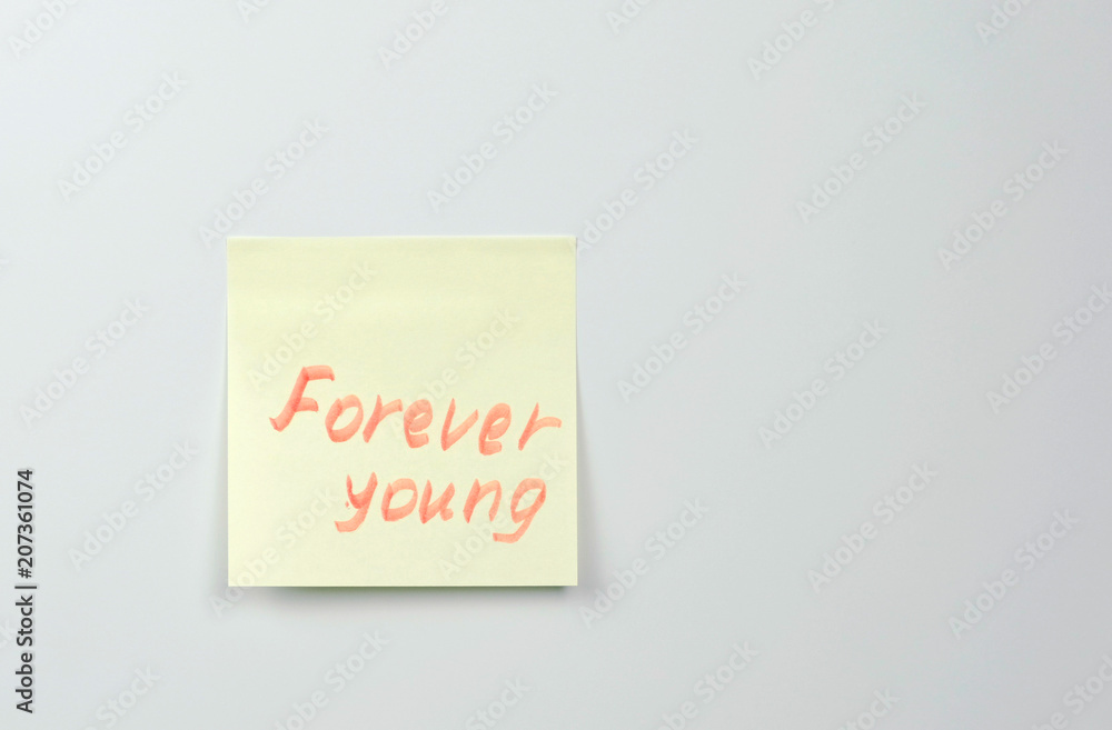 Note on yellow sticker paper sheets with motivation words forever young. Note on yellow sticker paper sheets with motivation words forever young.