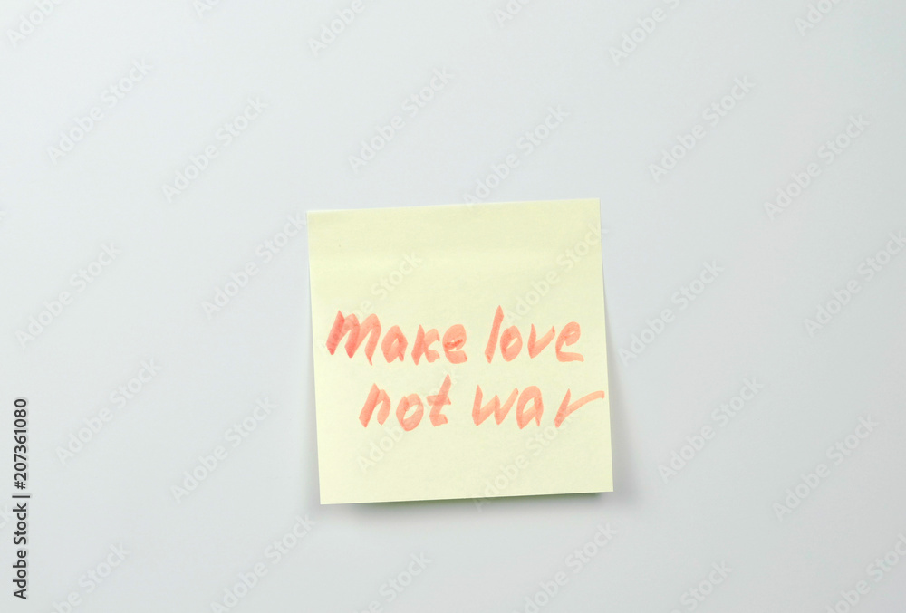 Note on yellow sticker paper sheets with motivation words make love not war. Note on yellow sticker paper sheets with motivation words make love not war.