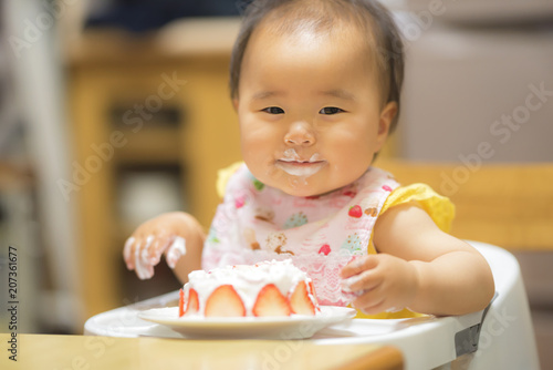 1歳の誕生日ケーキを食べる子供