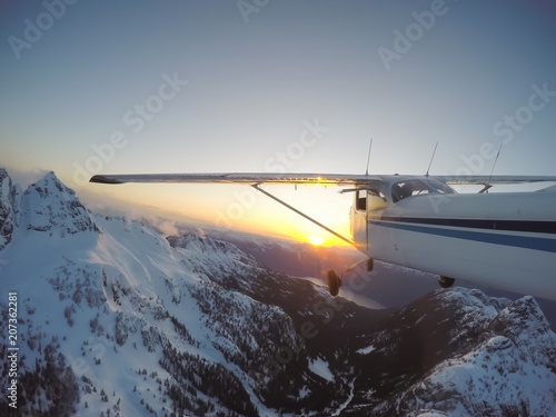 Airplane flying over the beautiful Canadian Landscape during a vibrant and colorful sunset. Taken near Vancouver, British Columbia, Canada.