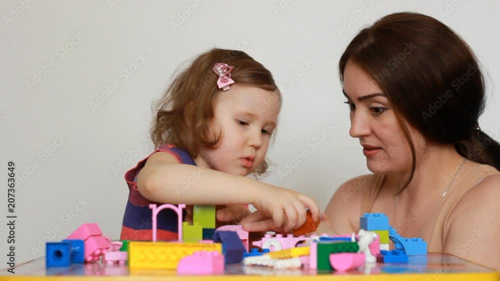 Mother and girl child busy building a constructor. Mother and girl child busy building a constructor.