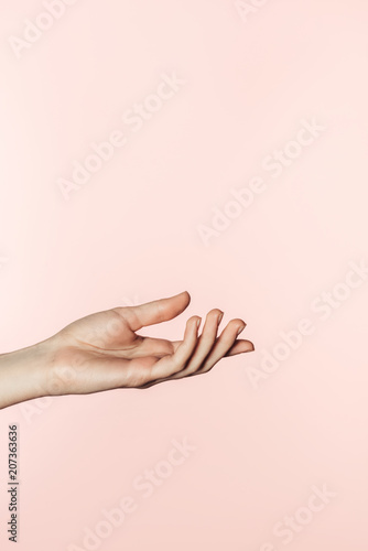 partial view of woman gesturing by hand isolated on pink background