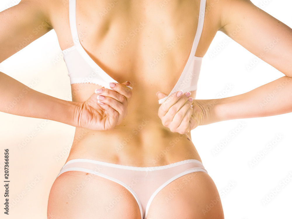 close-up on woman back with a hand try to take her bra off by unhooking the clasp of her bra.