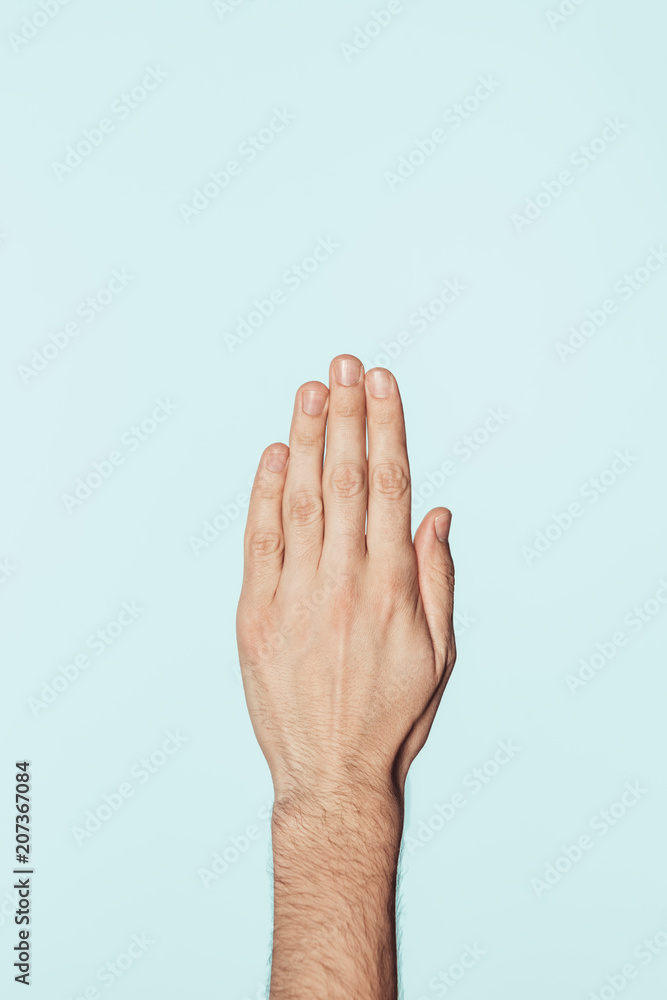 partial view of man gesturing by hand isolated on blue background partial view of man gesturing by hand isolated on blue background