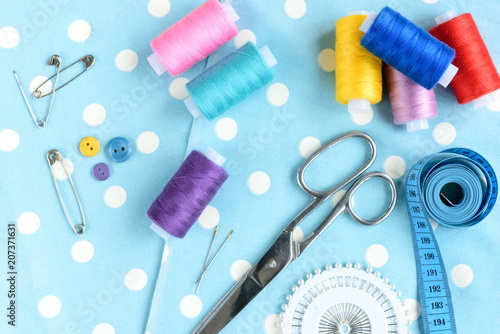 Threads and sewing accessories on wooden table with copy space