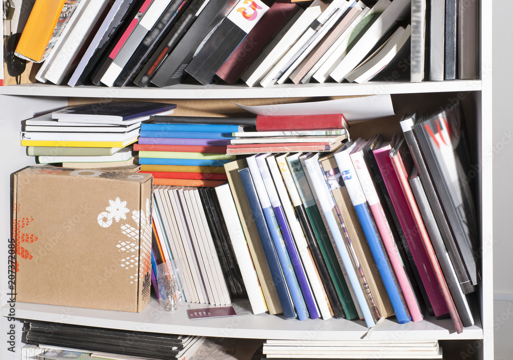 many different books on the shelves, in an open cupboard many different books on the shelves, in an open cupboard