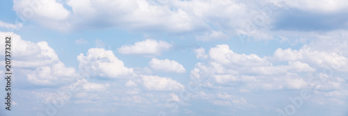panorama mit vielen weißen wolken vor blauem himmel
