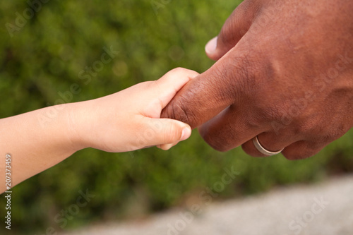 Close up of a father and son holding hands. © digitalskillet1