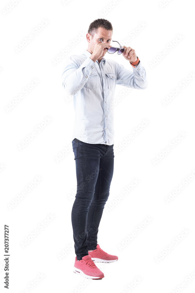 Cool macho handsome hunk put on sunglasses looking at camera. Full body isolated on white background. Cool macho handsome hunk put on sunglasses looking at camera. Full body isolated on white background.