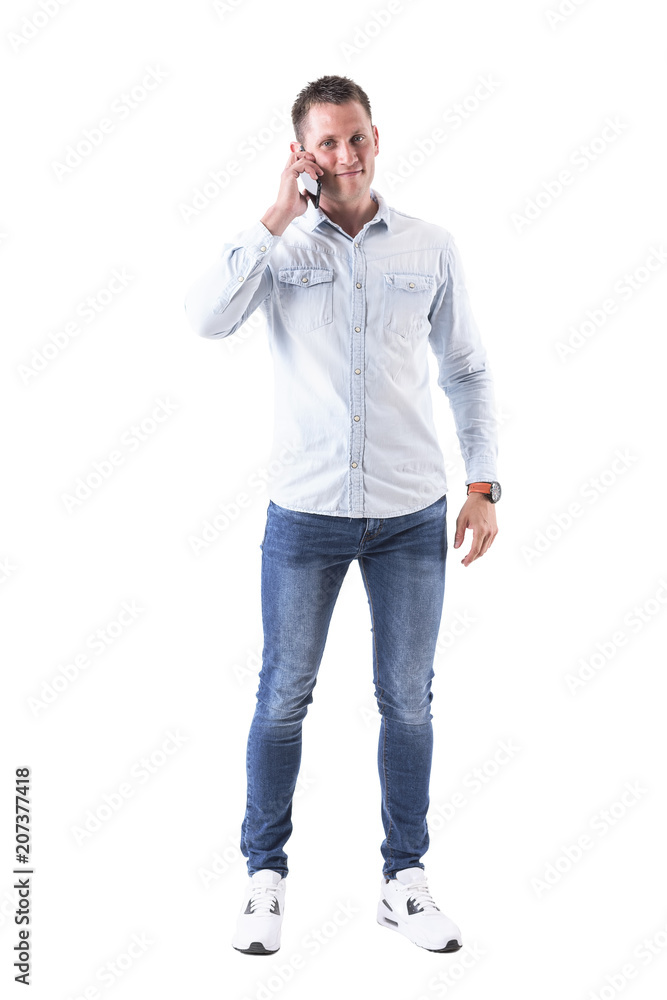 Happy young adult caucasian man talking on the mobile phone smiling at camera. Full body isolated on white background. Happy young adult caucasian man talking on the mobile phone smiling at camera. Full body isolated on white background.