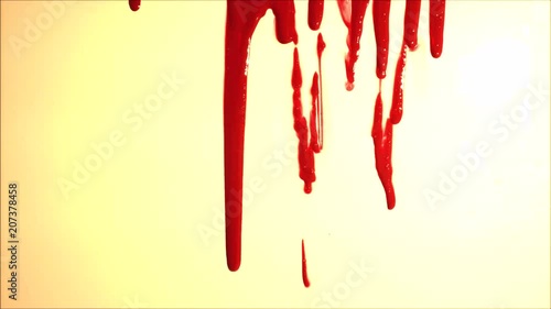 Blood splatter. Blood dripping down over light background. Red liquid.