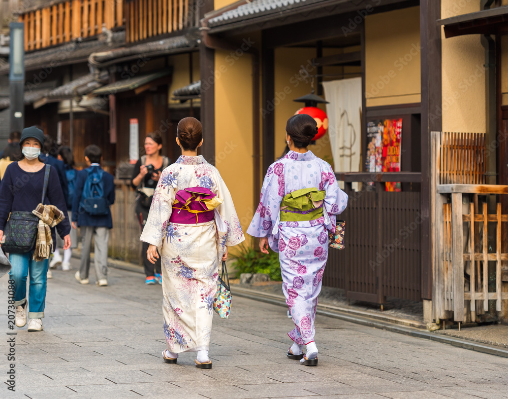 Fototapeta premium KYOTO, JAPAN - NOVEMBER 7, 2017: Girls in a kimono on a city street. Copy space for text.