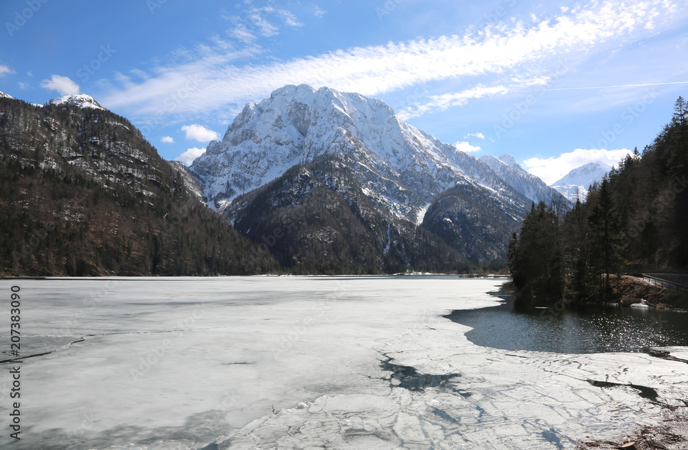 frozen little alpine lake called Lago del Predil in Italian Lang